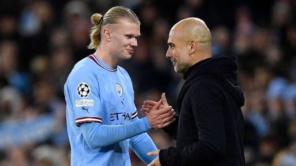 Erling Haaland (blue) shakes his manager Pep Guardiola (black)