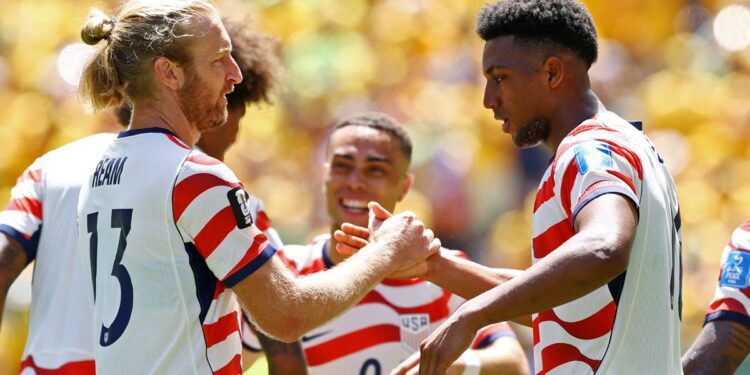 Alex Freeman congratulated by his teammates after scoring his first World Cup goal