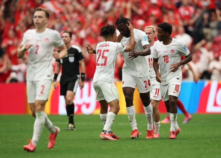 Canada players celebrating after making knockout round of the FIFA World Cup for the first time in their history