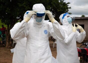DRC Ebola Response Suffers Major Setback After Centre Burns Down 3 Health workers in personal protective equipment (PPE)