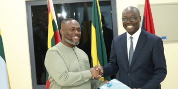 Outgoing Acting Minister for Defence Dr Cassiel Ato Forson, right, hands the Ministry of Defence handing-over notes to the incoming Minister, Kenneth Gilbert Adjei, at the ceremony in Accra. Photo: Ministry of Defence