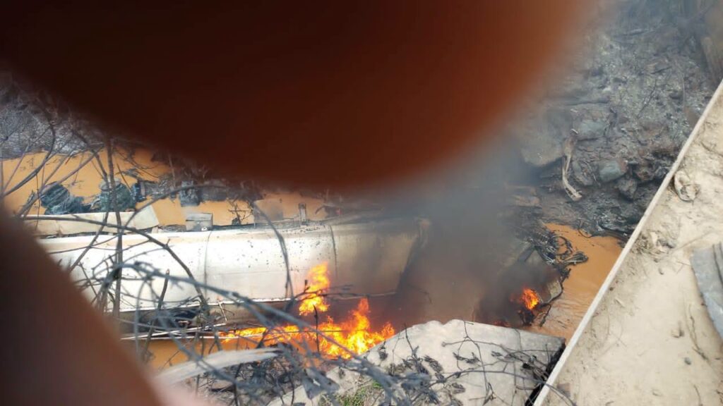 Smoke billows from the tanker wreckage in the river as the fire continues to burn following the pile-up crash at Birimso Bridge on the N6 highway.