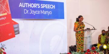 Dr Joyce Manyo speaks alongside a display of her newly launched book, Political Branding in Ghana, during the event's author's speech segment.