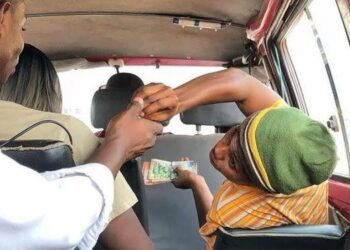 Transport Unions Announce No Fare Increase After Mahama's Diesel Cut 2 A commuter pays their fare inside a trotro, as transport unions confirm that fares remain unchanged across all routes following government's reduction in the diesel regulatory margin.