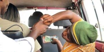 A commuter pays their fare inside a trotro, as transport unions confirm that fares remain unchanged across all routes following government's reduction in the diesel regulatory margin.