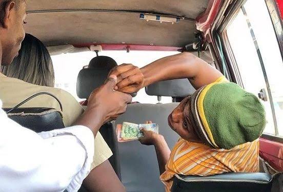 Transport Unions Announce No Fare Increase After Mahama's Diesel Cut 1 A commuter pays their fare inside a trotro, as transport unions confirm that fares remain unchanged across all routes following government's reduction in the diesel regulatory margin.