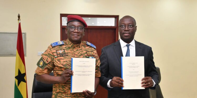 Ghana, Burkina Faso Sign Defence Pact To Secure Trade Corridors 1 Major General Célestin Simporé and Dr Cassiel Ato Baah Forson hold up the French and English texts of the Technical Arrangement on escort and security support for military equipment and convoys