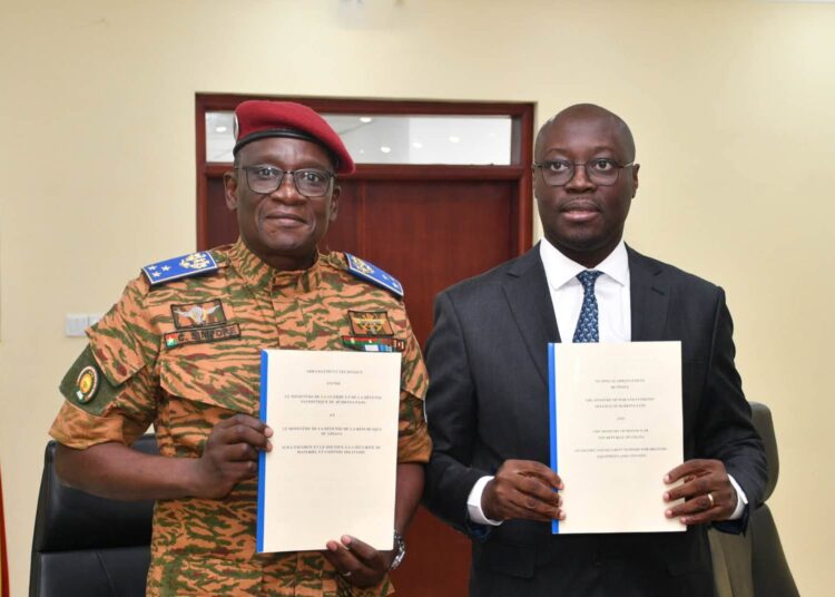 Ghana, Burkina Faso Sign Defence Pact To Secure Trade Corridors 1 Major General Célestin Simporé and Dr Cassiel Ato Baah Forson hold up the French and English texts of the Technical Arrangement on escort and security support for military equipment and convoys