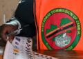 Zambia Suspends Vote Count Over Attacks on Election Officials 6 An election official holds a ballot at a polling station during Zambia's general elections