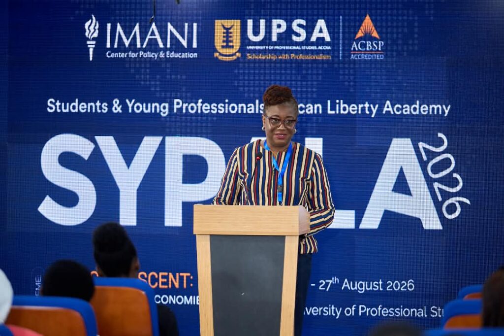 Bridget Dzogbenuku takes the podium at SYPALA 2026, hosted by IMANI, UPSA and ACBSP under the "Resilient Economies" theme.