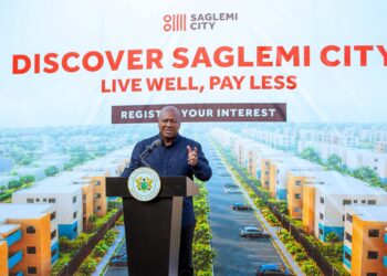 President Mahama speaks beneath a rendering of the completed estate, part of a "Live Well, Pay Less" campaign inviting Ghanaians to register interest in the revived Saglemi Housing Project.