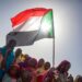UN Warns Sudan War’s Consequences Will Be Long-Lasting 12 Sudanese women wave the national flag during a pro-democracy rally