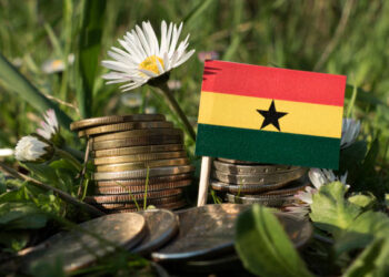 Ghana's 6.2% Growth Faces a Breadth Challenge 2 Ghanaian flag with stack of money coins with grass and flowers