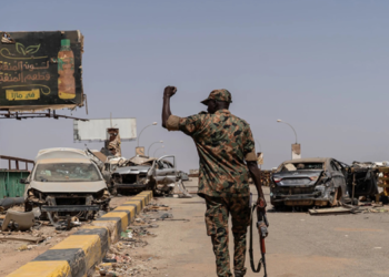 A soldier from the Sudanese Armed Forces (SAF) walking across the heavily damaged Shambat Bridge in Khartoum, Sudan