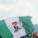 Protests Erupt in Nigeria Following Detainee Miners’ Deaths in Custody 14 The green and white flag with the national coat of arms of Nigeria being waved during an outdoor gathering or protest
