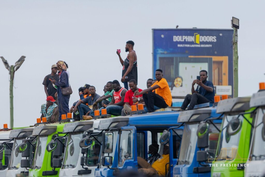 Mahama Unveils Agbogbloshie Urban Renewal Project As Waste Evacuation Begins 5 Drivers and operators wait atop a line of tipper trucks assembled for the exercise, which will haul an estimated one million tonnes of waste about 42 kilometres to the Adepa Engineered Landfill near Nsawam. Photo: The Presidency, Republic of Ghana