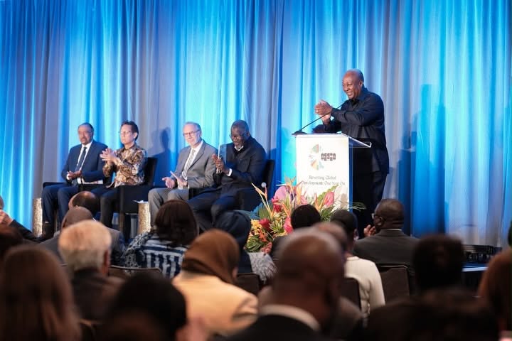 Mahama applauds from the podium alongside panel members at "Resetting Global Development: One Year On." He said the initiative is now moving from design to country-level execution.