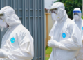 Health professionals in protective suits during a public health response