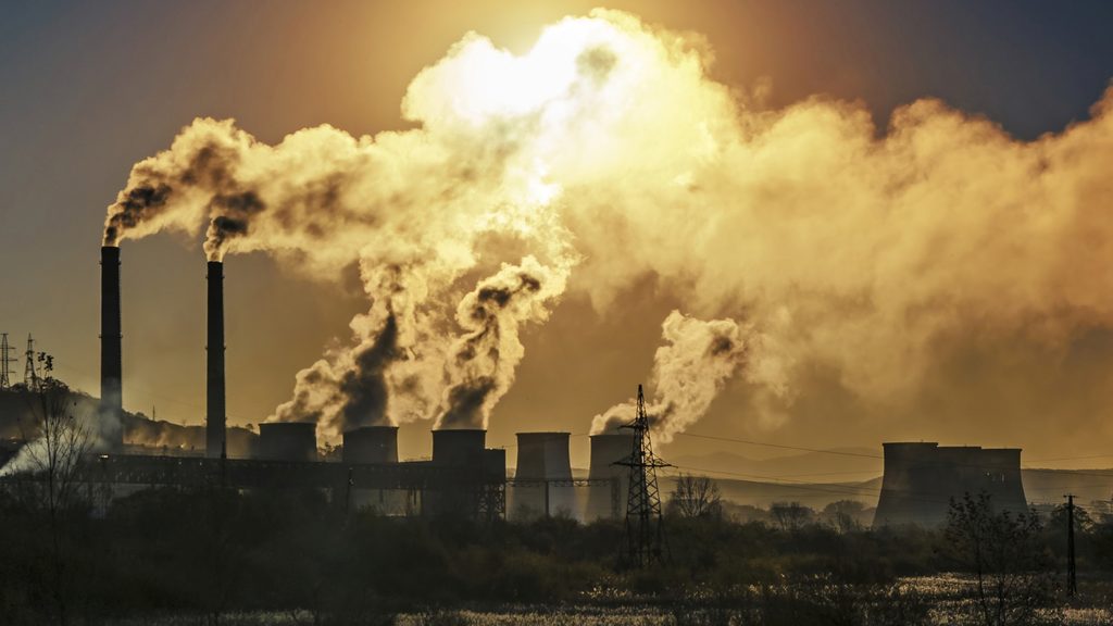 Industrial smoke and greenhouse gas emissions rising from a factory