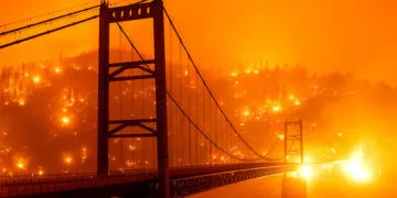Fire embers light up a hillside behind the Bidwell Bar Bridge. Image credit: AP