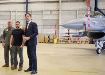 This photograph taken and released by the Ukrainian Presidential Press Service on 20 August 2023, shows Ukraine's President Volodymyr Zelenskyy (C) and Dutch Prime Minister Mark Rutte (R) standing next to a F-16 fighter jet in the hangar at the Eindhoven Military Air Base.
